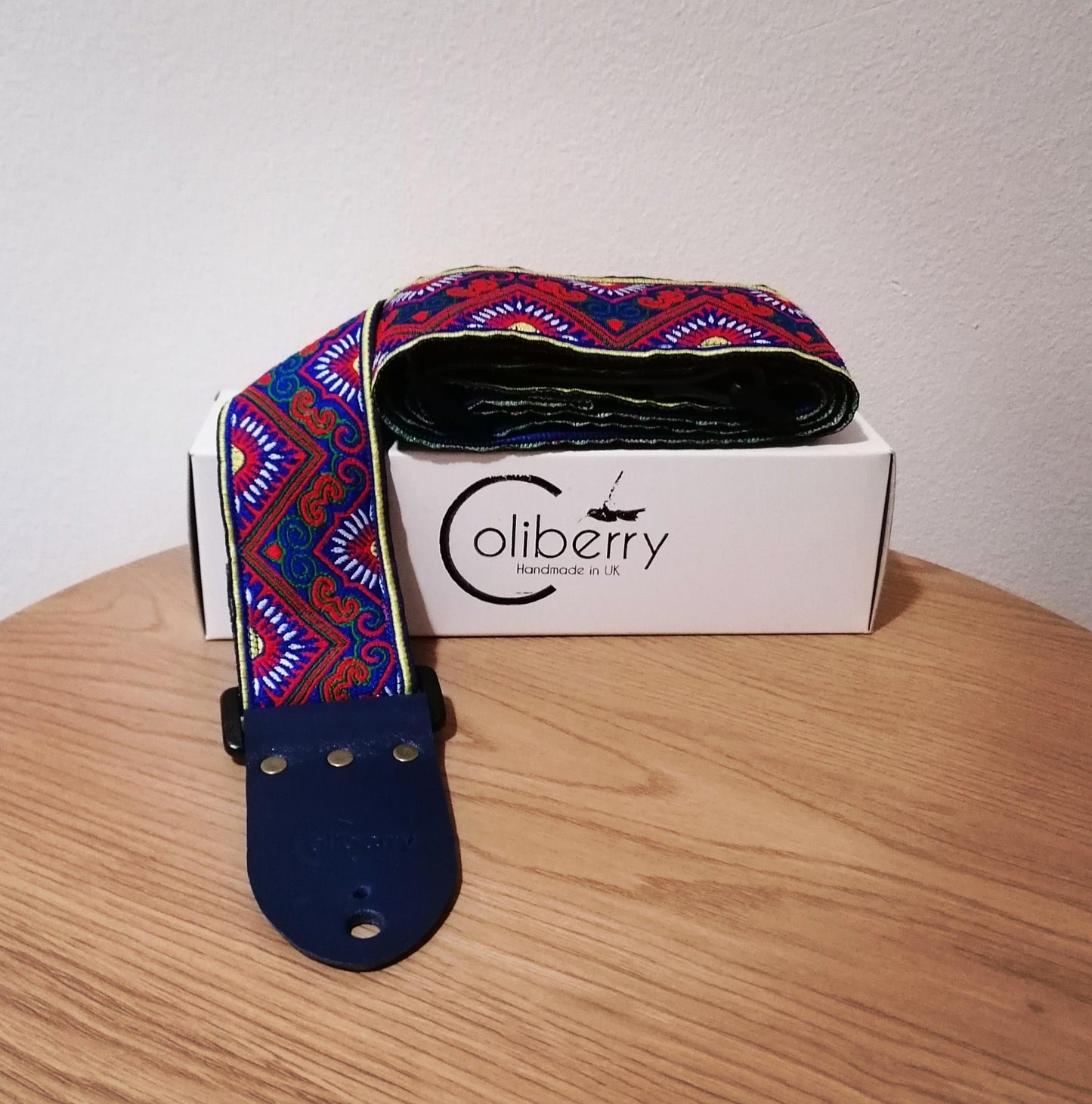 Handmade guitar strap - 'BlueTribal Horn' Blue, Red, Yellow Jaquard Ribbon with Blue Seatbelt backing and Antique Blue Real Leather ends.