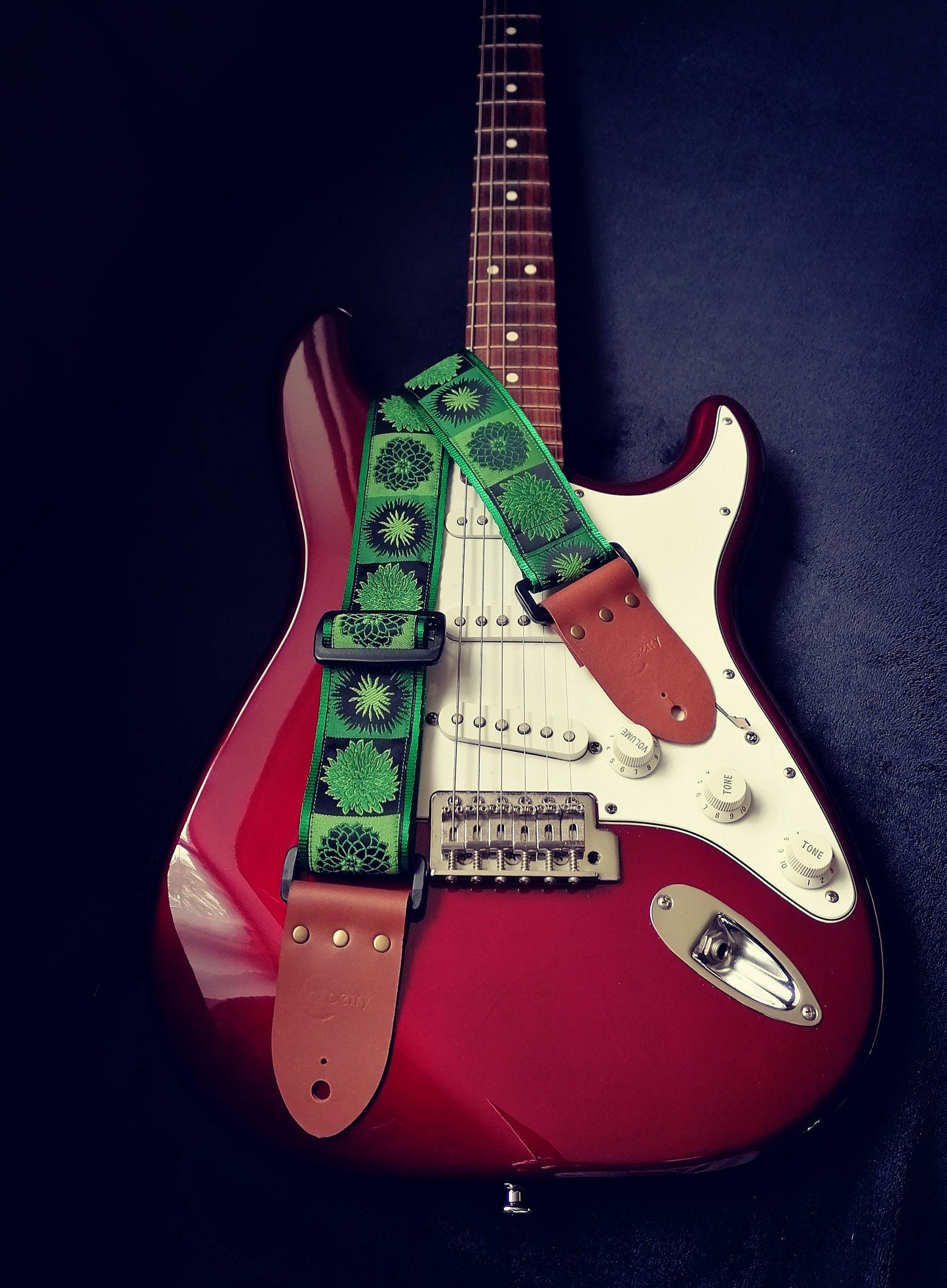 Handmade guitar strap. Flower Power available in 3 colours (Purple, Green, Red) with Seatbelt backing and Montana Hazelnut Real Leather ends