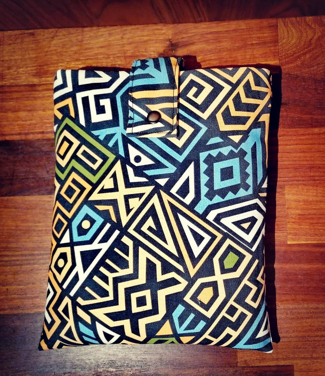 Handmade padded book sleeve/Tablet Covers, available in 2 funky patterns with snap on strap to the top.