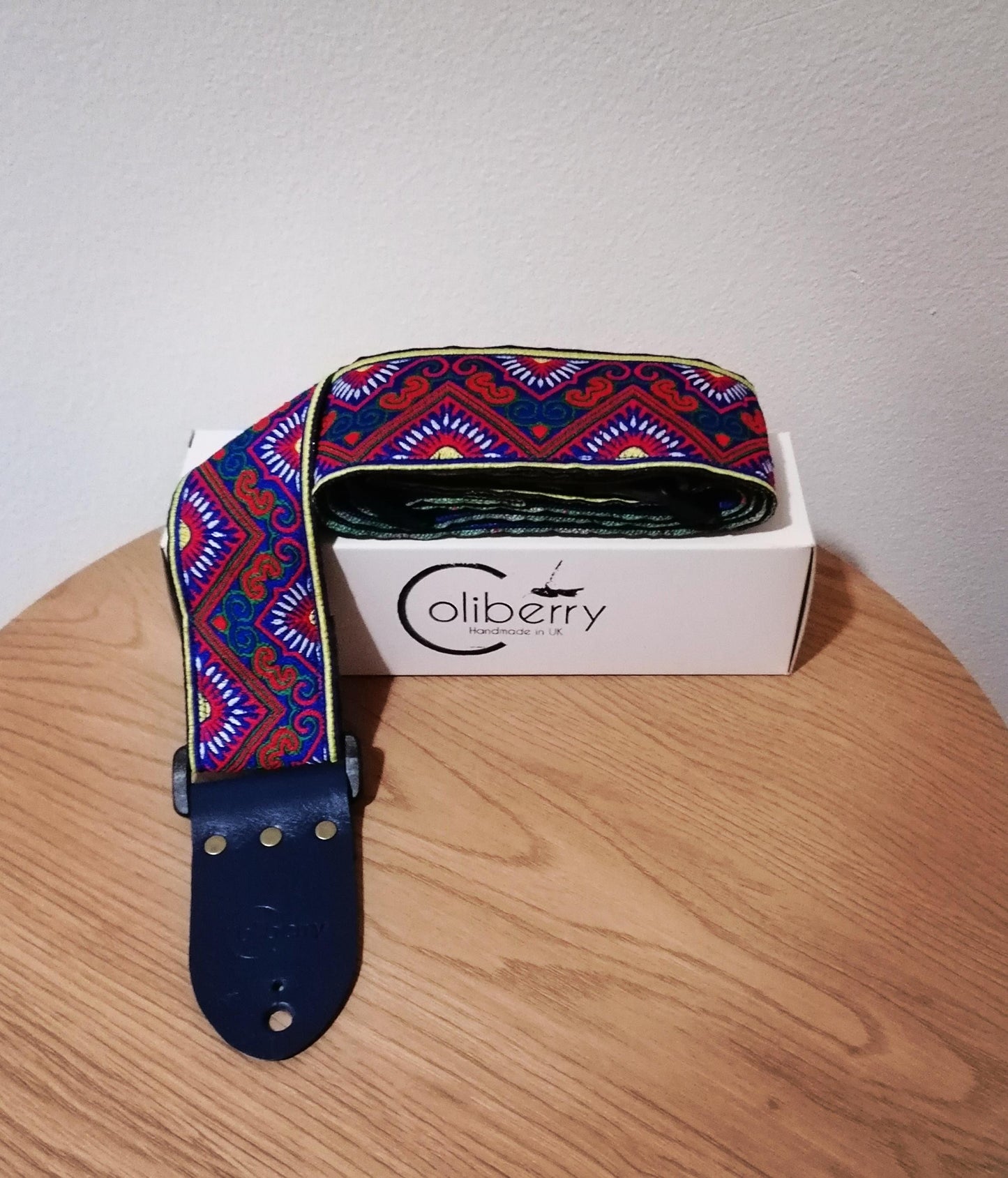 Handmade guitar strap - 'BlueTribal Horn' Blue, Red, Yellow Jaquard Ribbon with Blue Seatbelt backing and Antique Blue Real Leather ends.