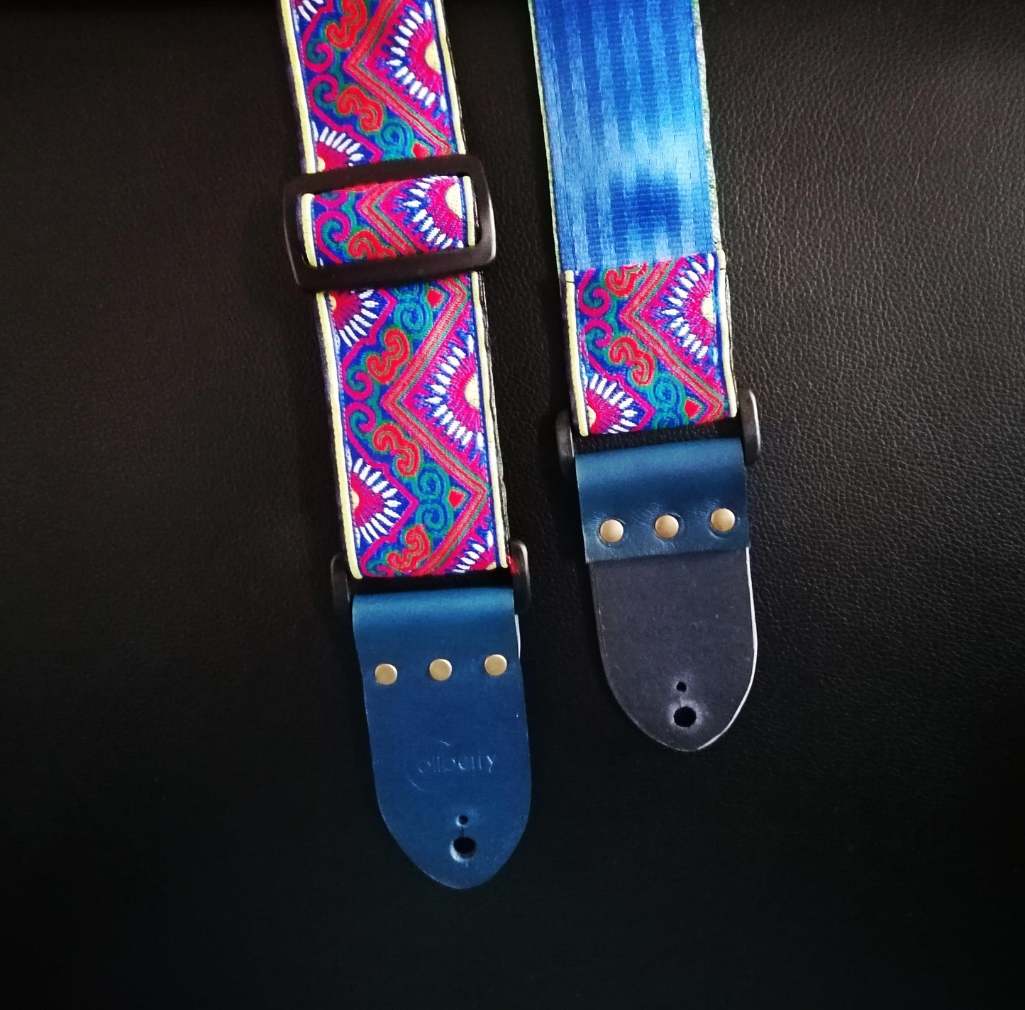 Handmade guitar strap - 'BlueTribal Horn' Blue, Red, Yellow Jaquard Ribbon with Blue Seatbelt backing and Antique Blue Real Leather ends.