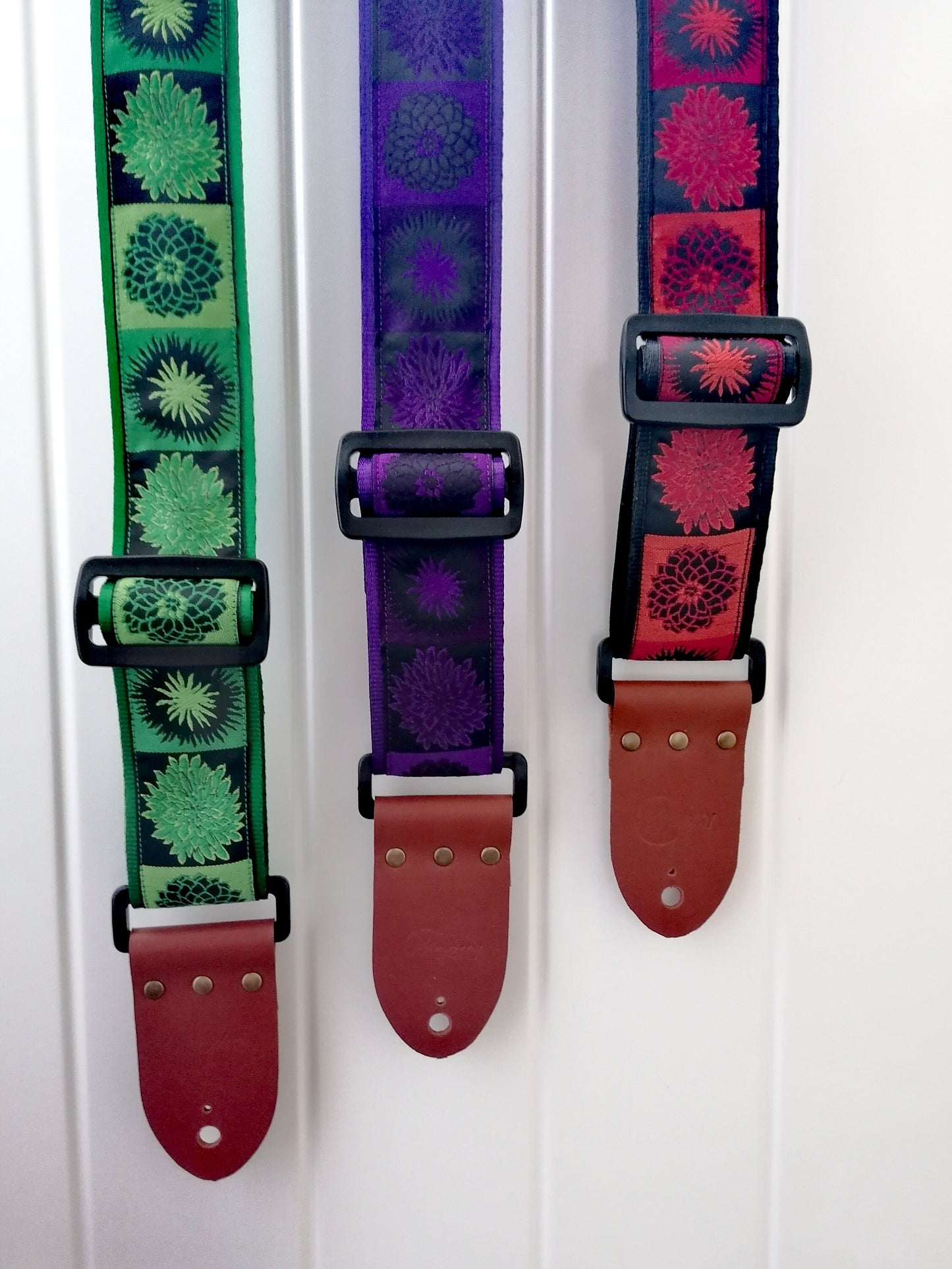 Handmade guitar strap. Flower Power available in 3 colours (Purple, Green, Red) with Seatbelt backing and Montana Hazelnut Real Leather ends