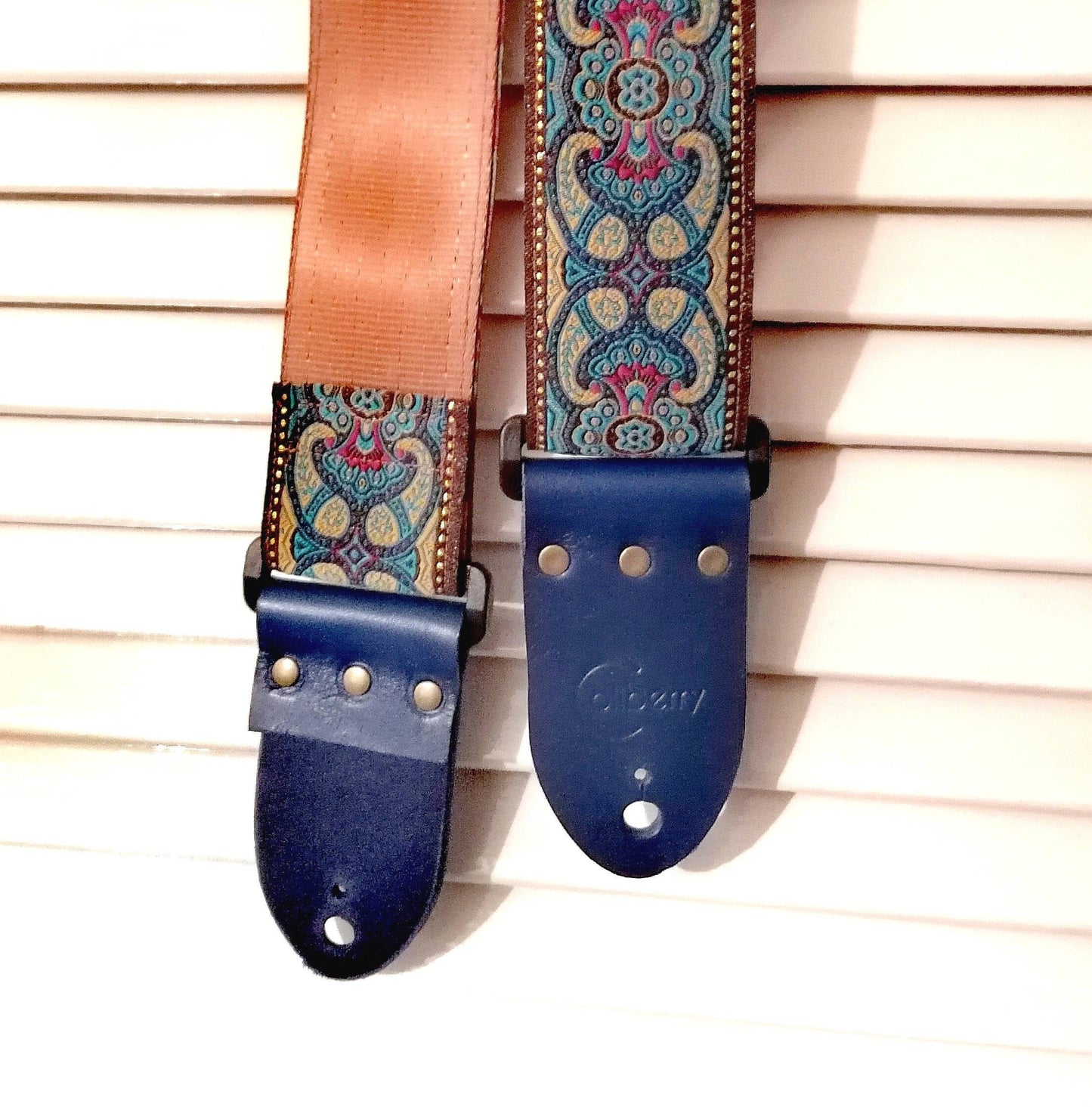 Handmade Guitar Strap with Baroque design jaquard ribbon to the front and tanned seatbelt backing, finished with blue real leather ends.