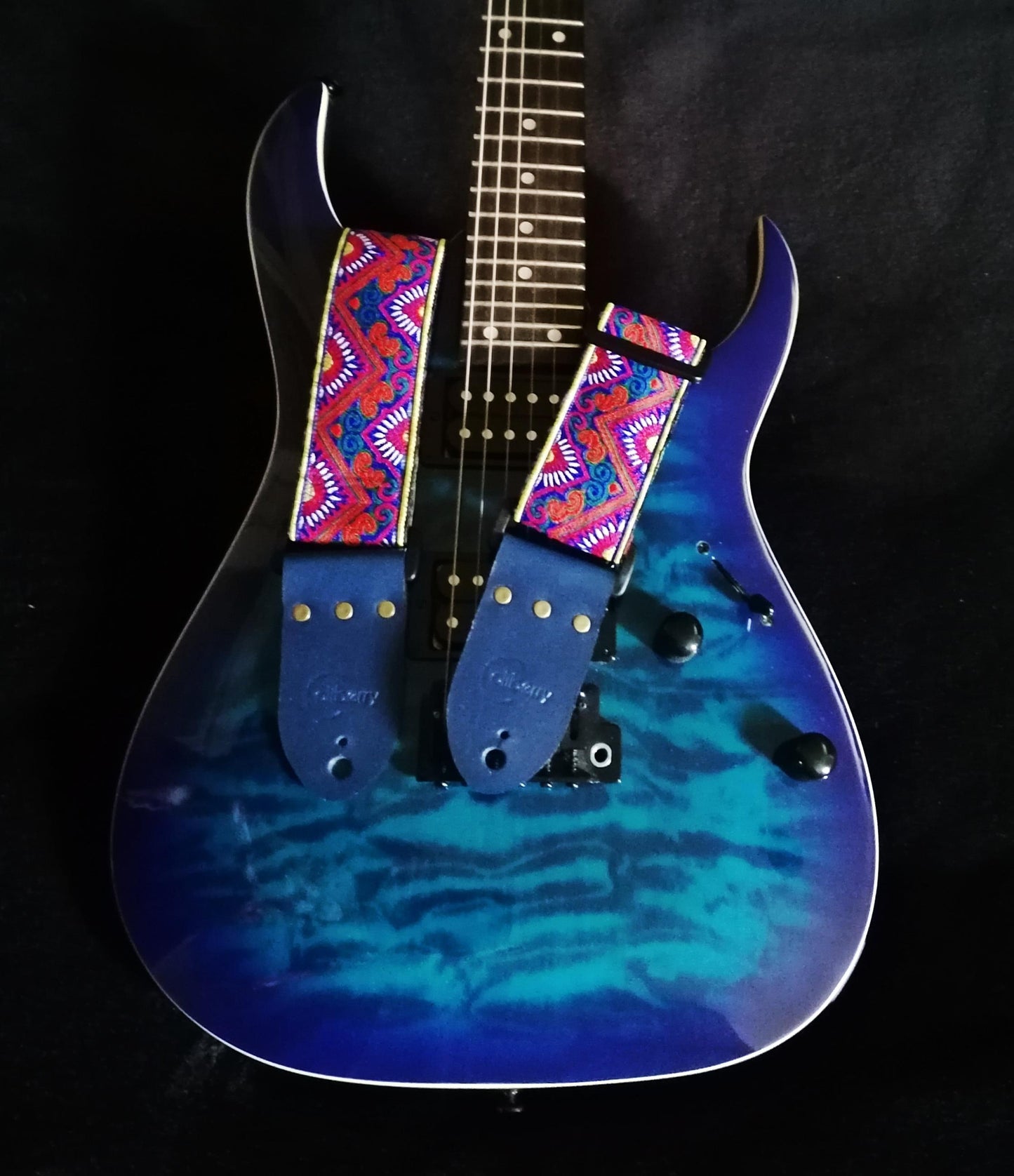 Handmade guitar strap - 'BlueTribal Horn' Blue, Red, Yellow Jaquard Ribbon with Blue Seatbelt backing and Antique Blue Real Leather ends.
