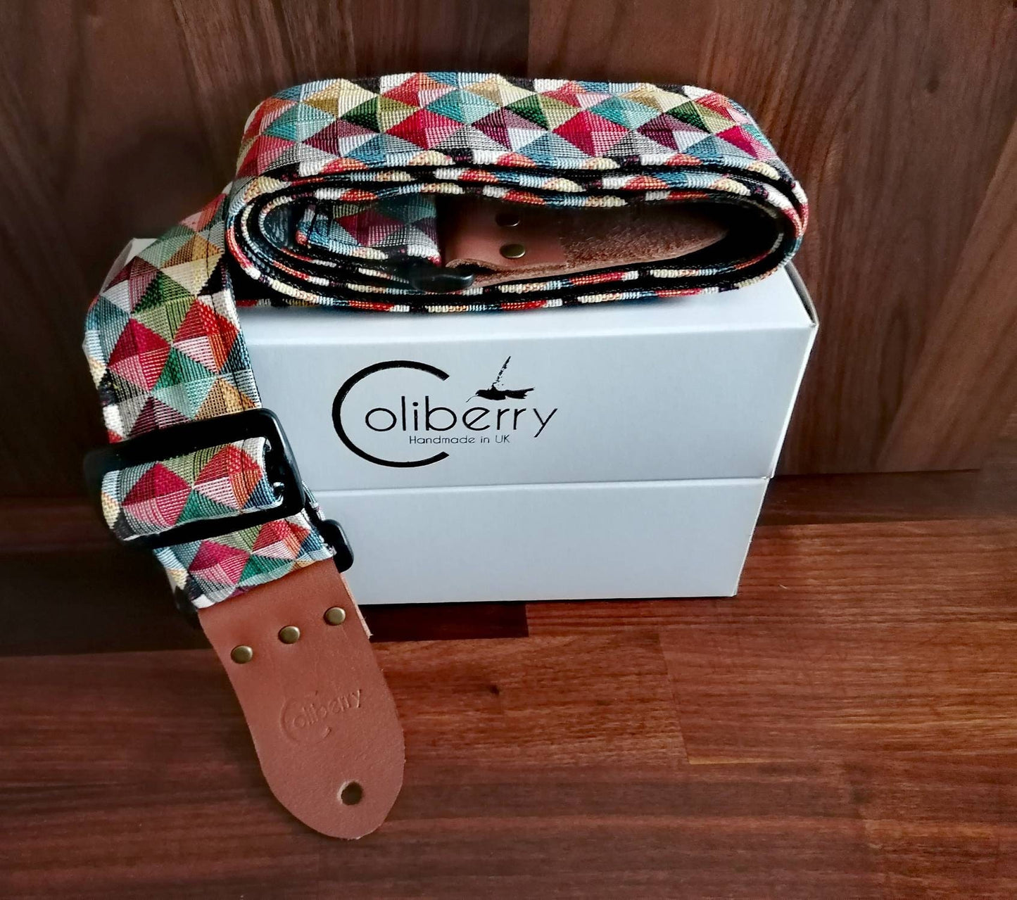 Handmade guitar strap. Multicolored 3D Squares design with black Seatbelt backing. Finished with Montana Hazelnut colour Real Leather ends.