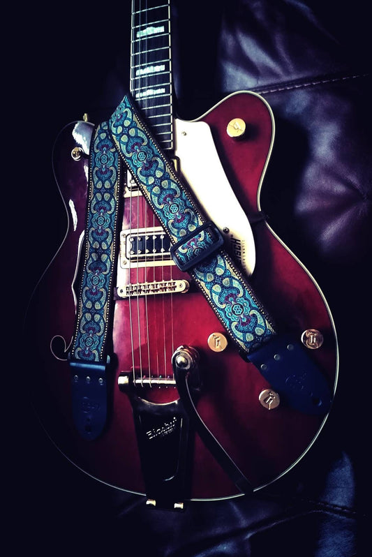 Handmade Guitar Strap with Baroque design jaquard ribbon to the front and tanned seatbelt backing, finished with blue real leather ends.