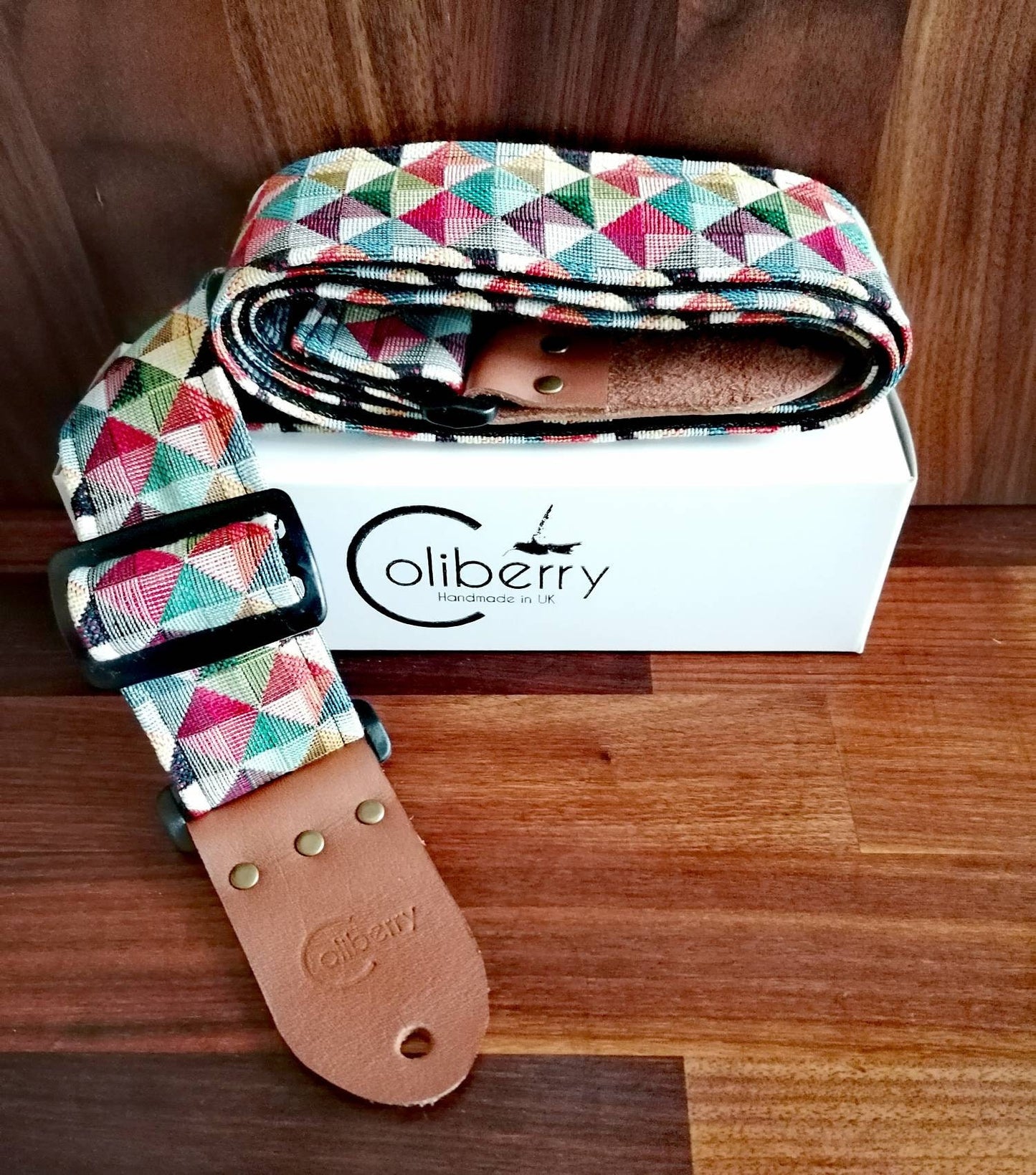 Handmade guitar strap. Multicolored 3D Squares design with black Seatbelt backing. Finished with Montana Hazelnut colour Real Leather ends.
