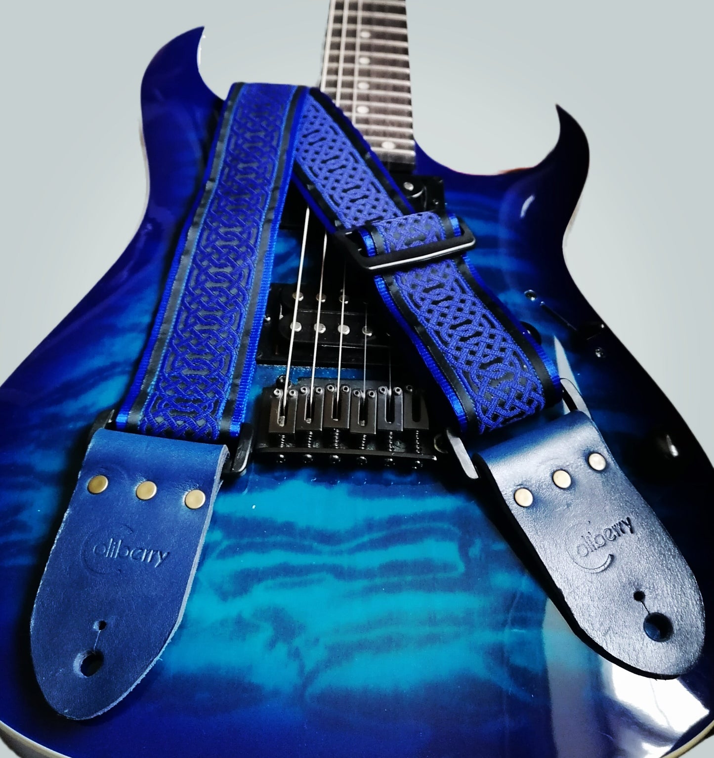 Handmade guitar strap - Blue Celtic pattern to the front with Royal Blue Seatbelt backing and Midnight Blue colour Real Leather ends.
