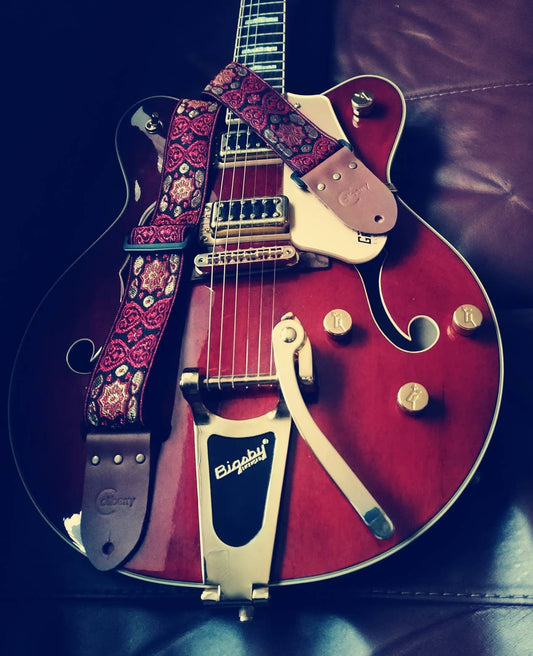 Handmade guitar straps with Baroque pattern Jaquard ribbon to the front and seatbelt backing finished with real leather ends.