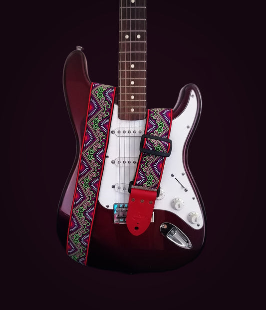 Handmade guitar strap - 'Red Tribal Horn' Red and Lime Jaquard Ribbon with Black Seatbelt backing and Antique Red Real Leather ends.