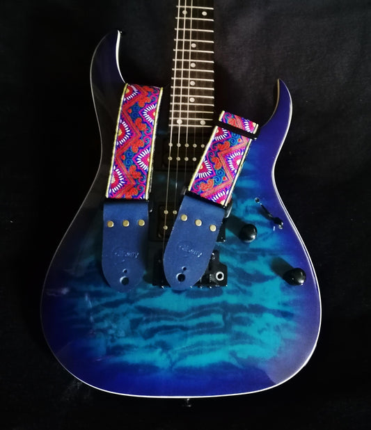 Handmade guitar strap - 'BlueTribal Horn' Blue, Red, Yellow Jaquard Ribbon with Blue Seatbelt backing and Antique Blue Real Leather ends.