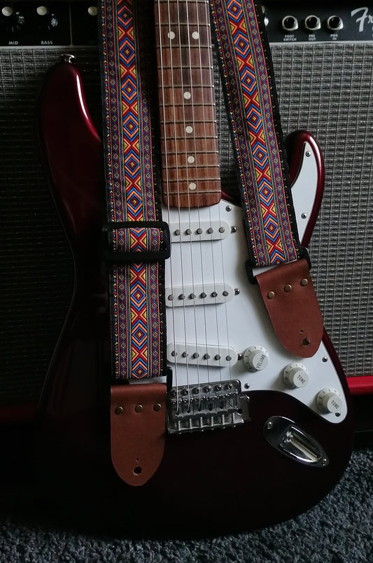 Handmade guitar strap - 'Bohemian' with multicolored design on front with Black Seatbelt backing and Montana Hazelnut Real Leather end.